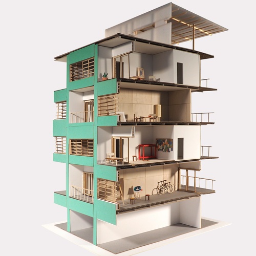 A section model of a housing structure with a green facade, balconies, and louvers along the openings. 