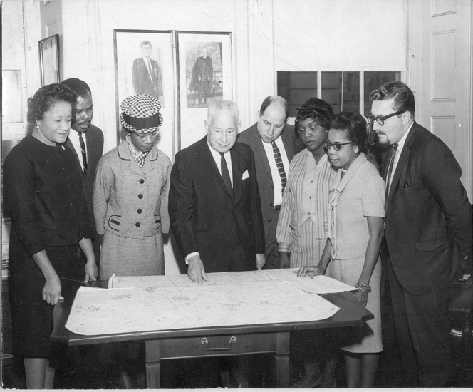 FIG. 1: In 1964 a group of ministers in Bedford-Stuyvesant requested tech- nical assistance from Pratt Center for Community Improvement (now Pratt Center for Community Development) to evaluate a city-sponsored urban renewal plan in their community. Pratt Institute’s Ron Shiffman (far right) joins local leaders in presenting the Bedford-Stuyvesant Alternative Plan to then-Brooklyn borough president Abe Stark (center). Shirley Chisholm, then a New York state assemblywoman and later the first African American woman in the US Congress, stands to Stark’s left (1966). Image is property of Pratt Center for Community Development.