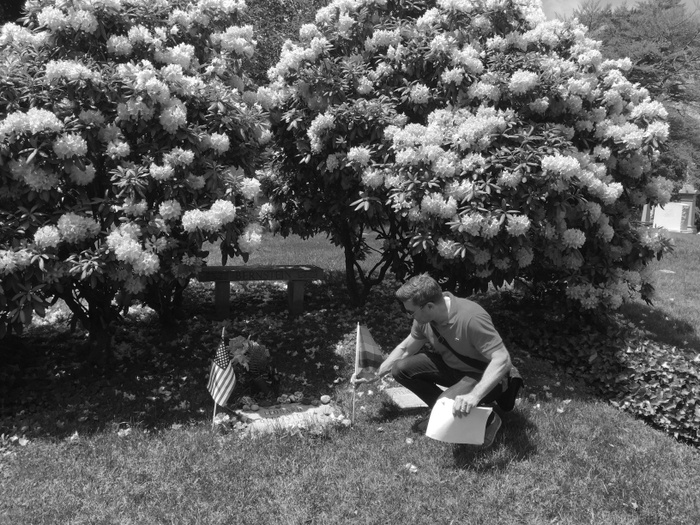 FIG. 8: Ken Lustbader, codirector of the NYC LGBT Historic Sites Project, planting a rainbow flag at the Green-Wood Cemetery grave of composer/conductor Leonard Bernstein, 2018. Photograph by Amanda Davis/NYC LGBT Historic Sites Project.