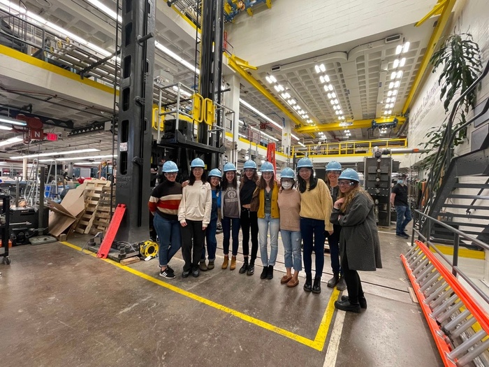 Students and faculty stand in a line, wearing hardhats